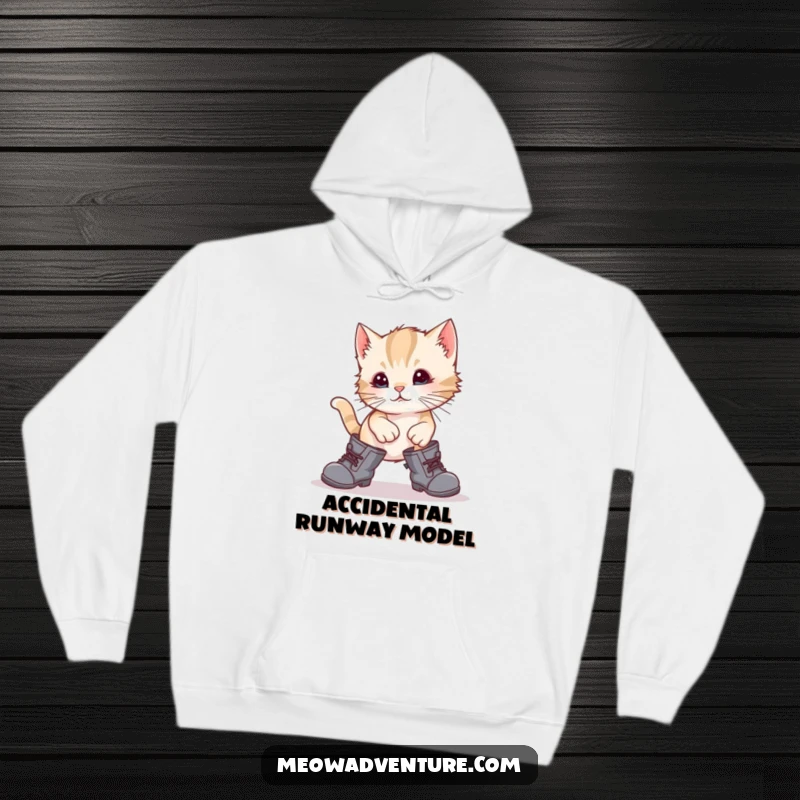 Funny, clumsy kitten wearing large boots, stumbling adorably on a soft hoodie, perfect for cat lovers and humor enthusiasts.