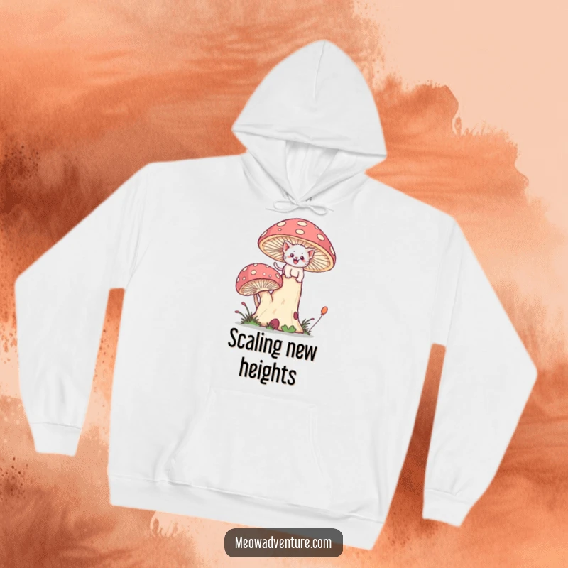 Funny warm hoodie depicting a brave kitten joyfully scaling a giant, whimsical mushroom with determined effort.