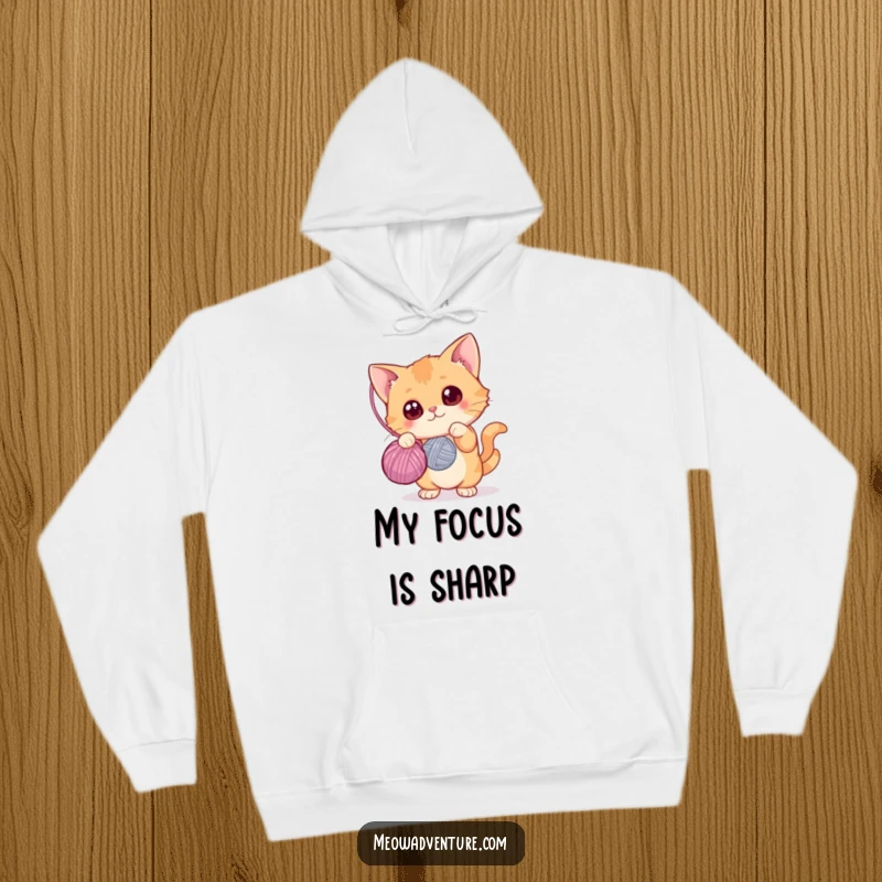 Funny hoodie design of a curious cat with wide eyes batting at a yarn ball, cozy and humorous apparel, great funny gift.