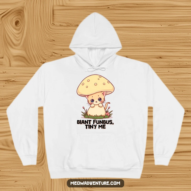 Funny hoodie with a curious kitten peeking from behind a large mushroom, offering warmth and a dose of adorable, humorous adventure.