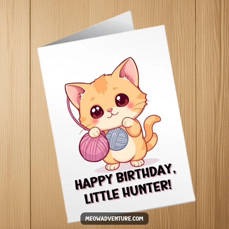 Funny free printable birthday card of a curious cat with wide eyes batting at a dangling ball of yarn, looking engaged.
