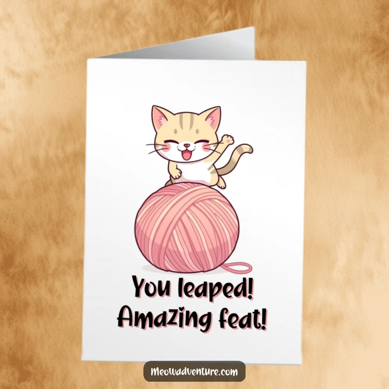 Funny Free Printable Congratulations Card: Determined cat triumphantly leaps over a giant yarn ball, celebrating success.