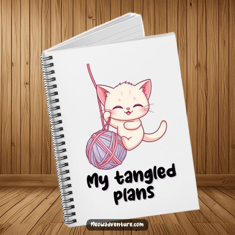Funny notebook with a brave kitten rappelling down a large ball of yarn, perfect for jotting down notes with a humorous, adventurous spirit.