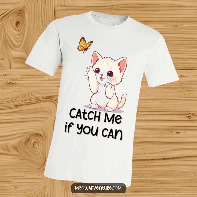 Funny curious kitten reaching up with paws to bat at a dangling butterfly, printed on a t-shirt, a playful scene.