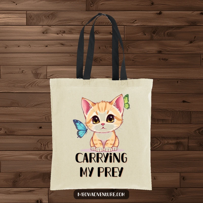 Funny Tote Bag showcasing a kitten intently fixated on a fluttering butterfly, embodying concentration and pursuit.