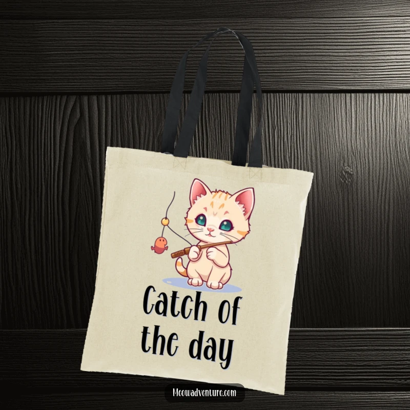 Funny cat tote bag: a curious kitten with a fishing rod, trying to catch a dangling toy mouse, looking determined.