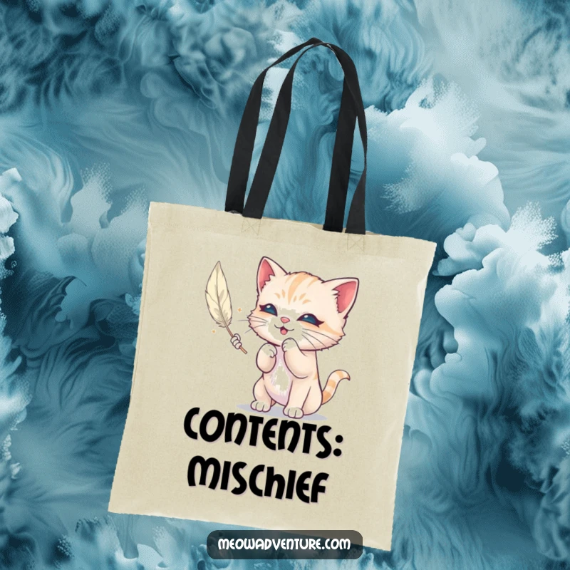 Funny tote bag featuring a mischievous kitten batting at a floating feather, perfect for carrying essentials with a touch of playful humor.