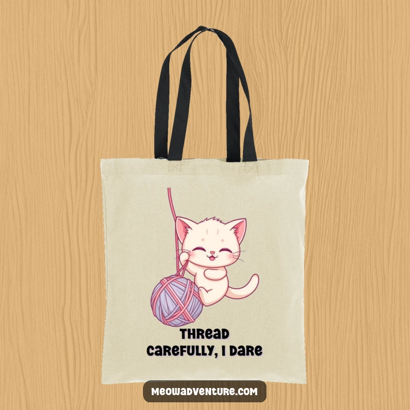 Funny tote bag designed with a brave kitten rappelling down a ball of yarn, perfect for carrying items with a humorous, adventurous flair.